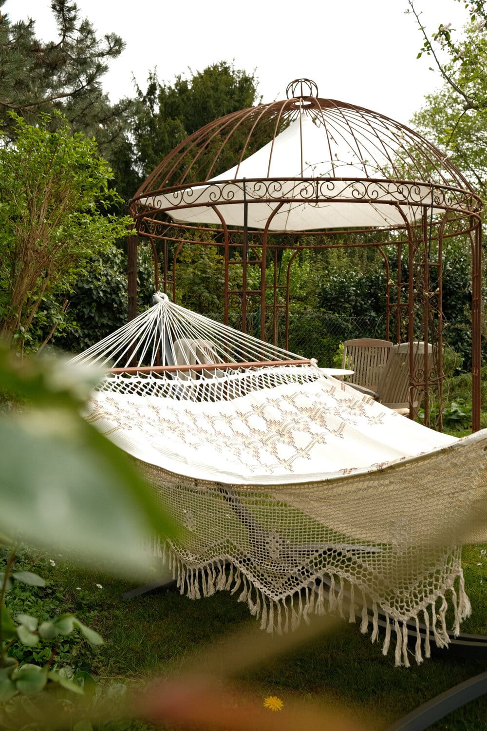 Amazonas Palacio Boho hängmatta i trädgården framför en pavillion
